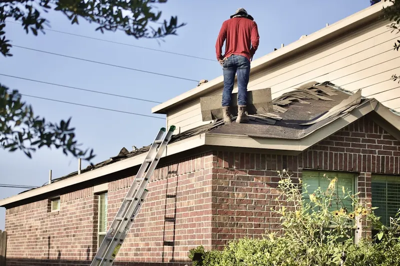 Professional roofer working on a residential roof in Bensville